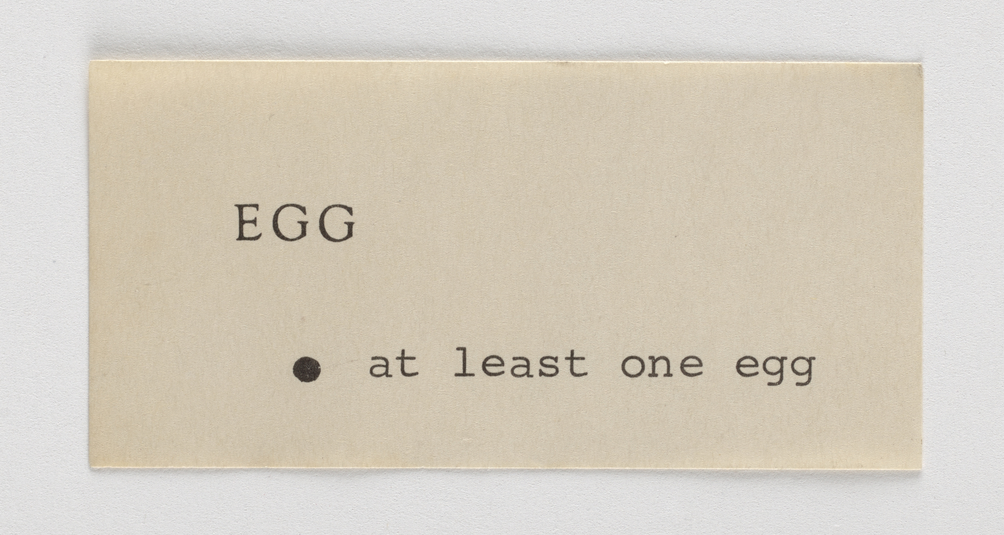 A rectangular piece of paper with the text “EGG” and “at least one egg” printed on it