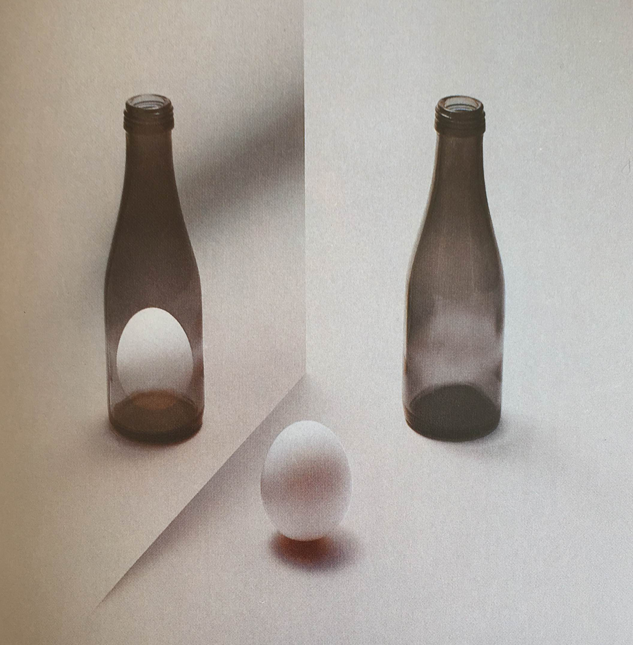 A photograph of an egg in the foreground and two bottles in the background. One of the bottles has an egg inside of it