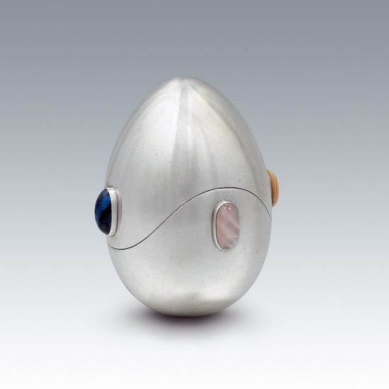 A futuristic-looking egg, made of metallic silver with different colored jewels inset